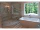 Beautiful bathroom with modern soaker tub, glass shower, and marble floors offering luxury and style at 1444 Old Apex Rd, Cary, NC 27513