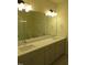 A neutral bathroom with double sinks, vanity, large mirror and a glass door walk-in shower in the background at 1444 Old Apex Rd, Cary, NC 27513
