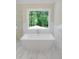 Bright and airy bathroom with a modern soaking tub positioned near a window at 1444 Old Apex Rd, Cary, NC 27513