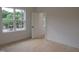 An unfinished bedroom features a large window, with wood flooring, and a neutral color palette at 1444 Old Apex Rd, Cary, NC 27513