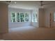 Spacious bedroom with large windows overlooking wooded landscape and a ceiling fan at 1444 Old Apex Rd, Cary, NC 27513