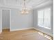 Open dining room featuring a chandelier, large window providing natural light, and light wood flooring at 1444 Old Apex Rd, Cary, NC 27513