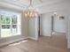 Bright dining room features a chandelier, large windows, and views into multiple rooms at 1444 Old Apex Rd, Cary, NC 27513