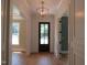 Bright foyer with elegant chandelier, hardwood floors, and detailed trim work throughout at 1444 Old Apex Rd, Cary, NC 27513