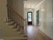 Elegant foyer with hardwood floors, decorative light fixture, craftsman trim, and stairs at 1444 Old Apex Rd, Cary, NC 27513