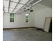 Two-car garage features a large window, white walls, and concrete floors at 1444 Old Apex Rd, Cary, NC 27513