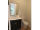 Elegant half bath featuring a black vanity and a stylish mirror at 1444 Old Apex Rd, Cary, NC 27513