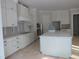 Bright, unfinished kitchen boasts white cabinets, a large island, and ample counter space at 1444 Old Apex Rd, Cary, NC 27513