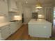 Modern kitchen with a large island, stainless steel appliances, and white cabinetry at 1444 Old Apex Rd, Cary, NC 27513