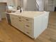 A large kitchen island featuring white countertops, a sink, and storage drawers, is the focal point of the room at 1444 Old Apex Rd, Cary, NC 27513