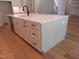 Kitchen island with white countertops, stainless steel dishwasher, storage drawers and cabinets, and modern fixtures at 1444 Old Apex Rd, Cary, NC 27513