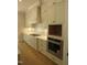 Modern kitchen with white cabinets, stainless steel appliances and gas range at 1444 Old Apex Rd, Cary, NC 27513