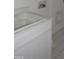 Bright laundry area features a utility sink with a white cabinet below and sleek gray tiled floors at 1444 Old Apex Rd, Cary, NC 27513