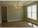 Sunlit living room with tray ceiling, chandelier, and large window at 1444 Old Apex Rd, Cary, NC 27513