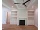 Spacious living room features hardwood floors, fireplace with marble surround, built-in shelving, and modern lighting at 1444 Old Apex Rd, Cary, NC 27513