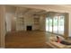 Open-concept living room with fireplace, built-in shelves, and glass patio doors at 1444 Old Apex Rd, Cary, NC 27513