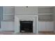 Bright living room featuring a fireplace with built-in shelving and cabinets, offering ample storage at 1444 Old Apex Rd, Cary, NC 27513