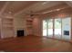 Bright living room boasts hardwood floors, built-in shelving, fireplace, and sliding glass doors to outdoor space at 1444 Old Apex Rd, Cary, NC 27513