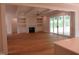Open-concept living room with fireplace, built-in shelving, and access to outdoor space at 1444 Old Apex Rd, Cary, NC 27513