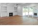 Bright living room with a fireplace, built-in shelving, and glass doors to the outdoor patio at 1444 Old Apex Rd, Cary, NC 27513
