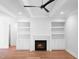 Bright living room featuring coffered ceilings, fireplace, built-in shelving, and light wood flooring at 1444 Old Apex Rd, Cary, NC 27513