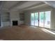 Sunlit living room featuring a fireplace, built-in shelves, and sliding glass doors at 1444 Old Apex Rd, Cary, NC 27513