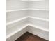 Pantry with ample white shelving and hardwood flooring at 1444 Old Apex Rd, Cary, NC 27513