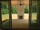 View of backyard patio through sliding glass doors, featuring an outdoor fireplace at 1444 Old Apex Rd, Cary, NC 27513