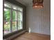 Well-lit room with hardwood floors, large windows, and decorative wall paneling at 1444 Old Apex Rd, Cary, NC 27513