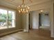 Spacious room with hardwood floors, coffered ceiling, and construction visible outside at 1444 Old Apex Rd, Cary, NC 27513