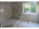 Partially finished shower with marble-patterned tile, built-in bench, and bright window at 1444 Old Apex Rd, Cary, NC 27513
