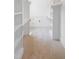 Bright walk-in closet with built-in shelving with wooden closet rods and access door to storage at 1444 Old Apex Rd, Cary, NC 27513