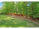 A lush backyard lined with mature trees and a well-maintained lawn create a serene outdoor space at 1613 Waddell Ct, Durham, NC 27703