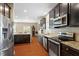 Modern kitchen featuring stainless steel appliances, granite countertops, and dark wood cabinets at 1613 Waddell Ct, Durham, NC 27703
