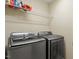 Functional laundry room with modern washer and dryer, complemented by a wire shelf for added storage and organization at 1613 Waddell Ct, Durham, NC 27703