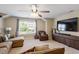 Bright living room with comfortable seating, a ceiling fan, and natural light from a nearby window at 1613 Waddell Ct, Durham, NC 27703