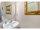 Stylish powder room with elegant oval mirror, gold accents, and a modern sink at 1613 Waddell Ct, Durham, NC 27703