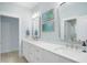 Bathroom with double sinks, vanity and mirrors with natural lighting and blue accents at 165 Alpine Rd, Moncure, NC 27559