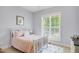 Bright bedroom with a comfortable bed, natural light, and a view of lush greenery at 165 Alpine Rd, Moncure, NC 27559