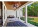 Covered patio with ceiling fan, a couch, and view of a wooded backyard at 165 Alpine Rd, Moncure, NC 27559