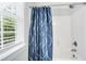 Bright shower with blue curtain and natural light streaming through the window at 165 Alpine Rd, Moncure, NC 27559