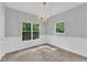 Dining room with multiple windows, chandelier, white trim, and neutral tile flooring at 1767 Quince Loop, Sanford, NC 27332