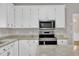 Renovated kitchen with white cabinetry, stainless steel appliances, granite counters, and kitchen island at 1767 Quince Loop, Sanford, NC 27332