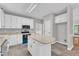Bright kitchen features white cabinets, stainless steel appliances, and granite countertops, with a center island at 1767 Quince Loop, Sanford, NC 27332