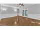Open living room boasts wood floors, french doors, white trim, and a ceiling fan at 1767 Quince Loop, Sanford, NC 27332