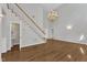 Open-concept living room with staircase, wood floors, and chandelier, creating an inviting atmosphere at 1767 Quince Loop, Sanford, NC 27332