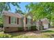 Charming single-story home with tan siding, red shutters, an American flag, and an attached garage at 1998 Ferbow St, Creedmoor, NC 27522