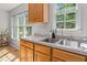 Kitchen area featuring double sink, wood cabinets, and natural light at 1998 Ferbow St, Creedmoor, NC 27522