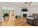 Spacious living room featuring hardwood floors, fireplace, and an open view of dining room at 1998 Ferbow St, Creedmoor, NC 27522