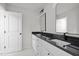 Bright bathroom featuring double vanity with black countertop and framed mirrors at 2015 Cheek Rd, Durham, NC 27704